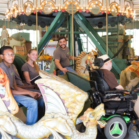 A man in a wheel chair at a merry go round