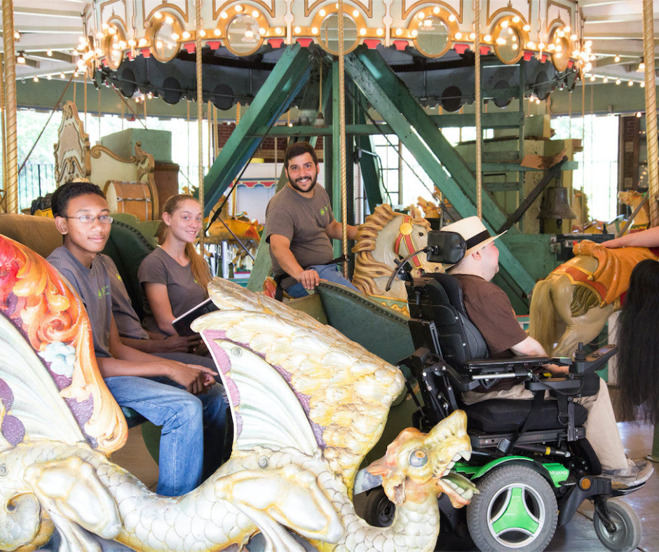 A man in a wheel chair at a merry go round