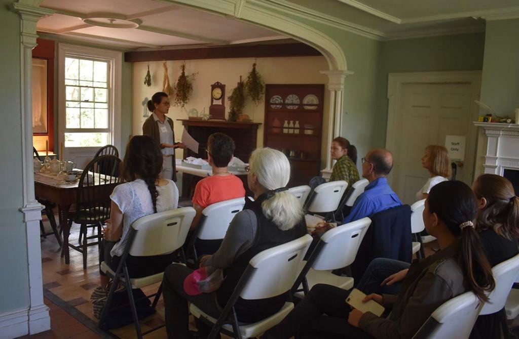 visitors listening to a presentation inside the Lefferts Historic House Museum