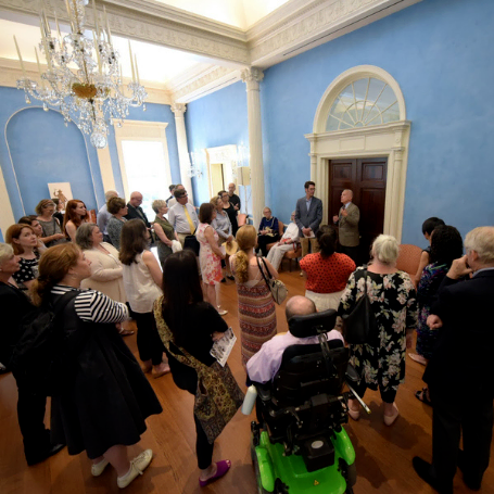 Members gathering in a room listening to a presentation