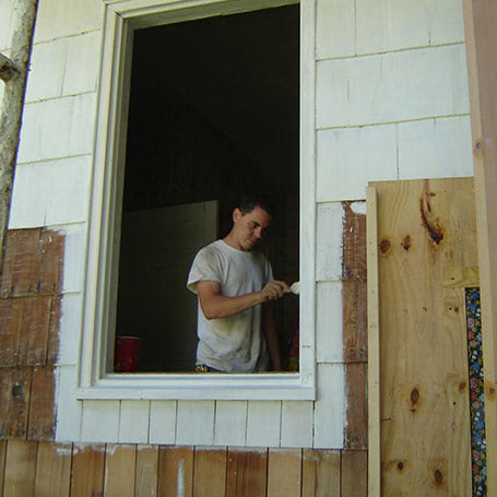 A man painting a window