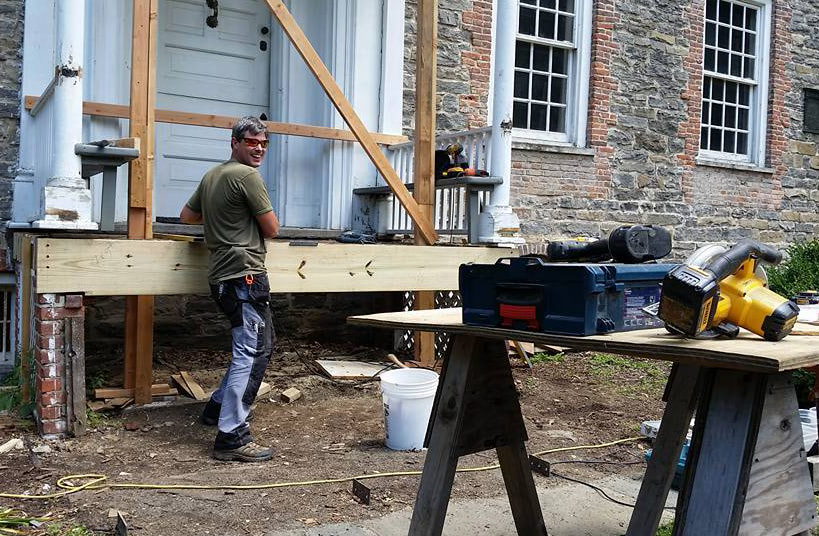 Workers fixing a porch of a historic house