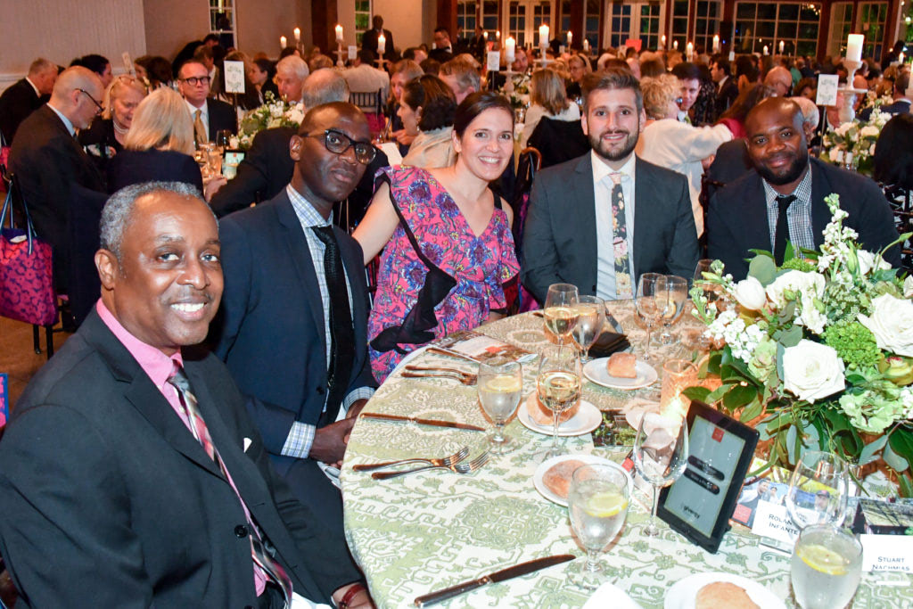 Annual Gala attendees posing for a photograph at a dinner table