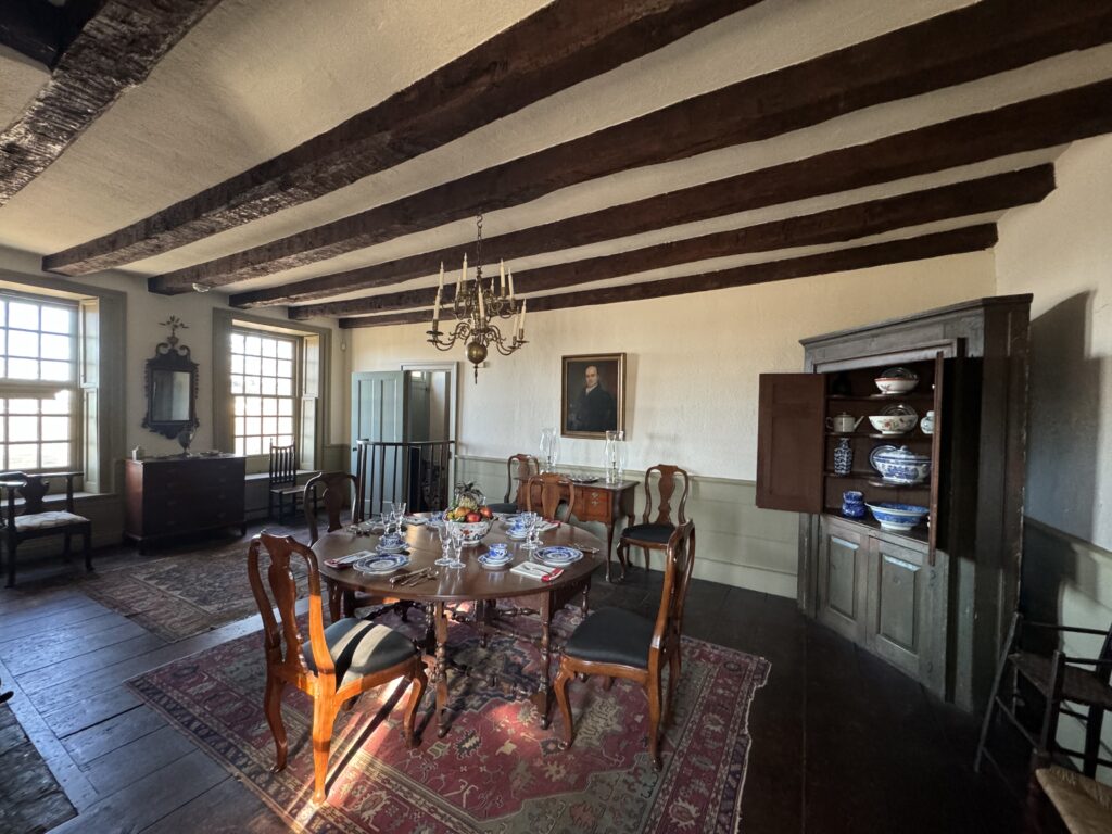 Color photo of historic interior dining room with table set with white and blue plates