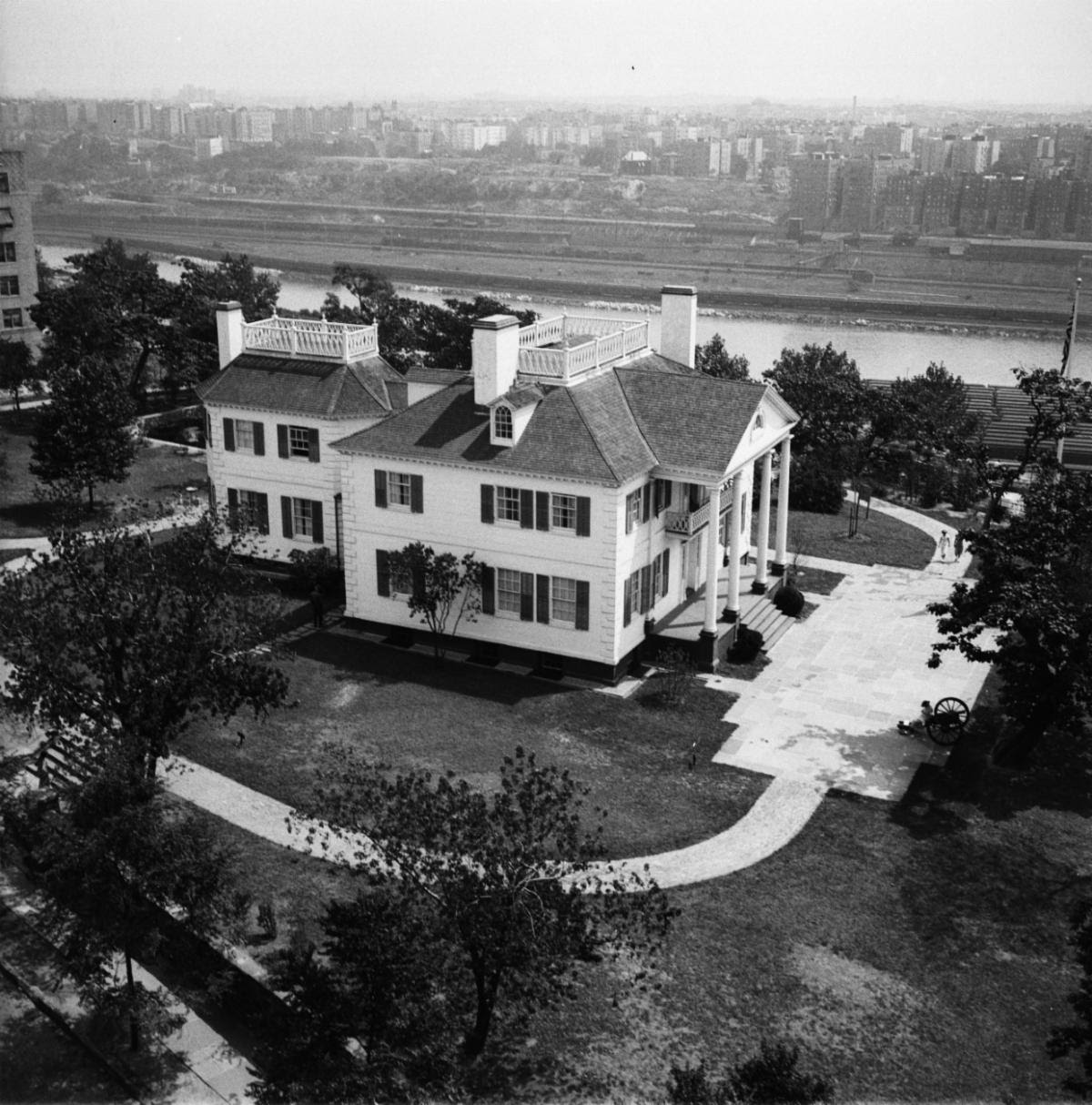 Black and white aerial photo of large white mansion.